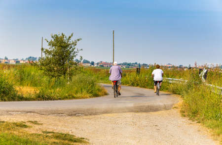 elderly couple cycling for the green Italian countrysideの写真素材
