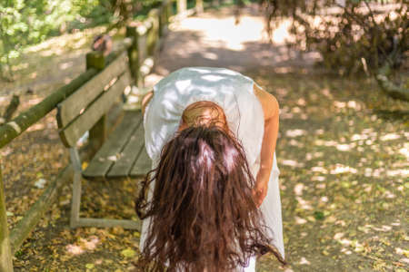 woman bends showing dangling hairの写真素材