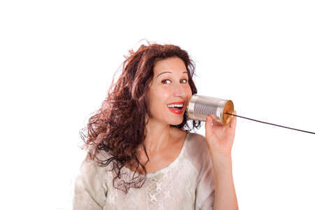 portrait of a cute middle aged woman talking with tin can phones isolated over a white backgroundの写真素材