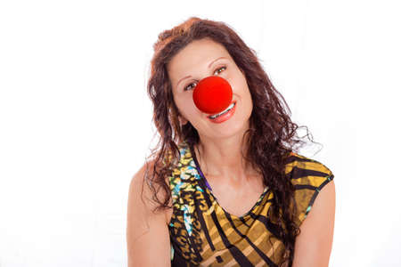 classy mature woman wearing a red clown nose isolated on whiteの写真素材