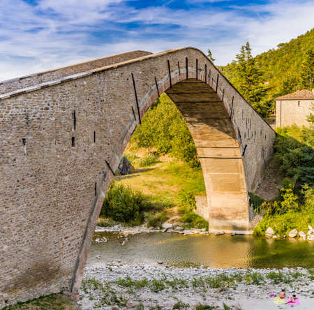 500 years old hog backed Renaissance bridge connecting two banks with single span in Italian Countrysideの写真素材