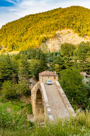 car crossing ancient hunchback bridge in Emilia Romagna