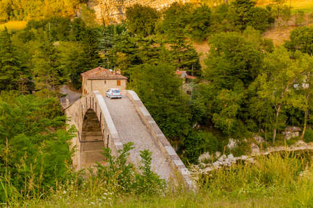 car crossing ancient hunchback bridge in Emilia Romagnaの写真素材