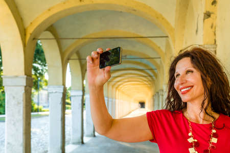 mature tourist taking a selfie in porticoの写真素材