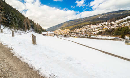 country road leading through a winter mountain landscape.の写真素材