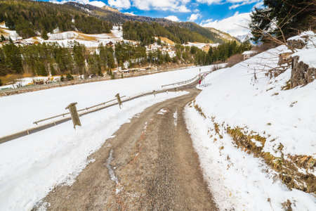 country road leading through a winter mountain landscape.の写真素材
