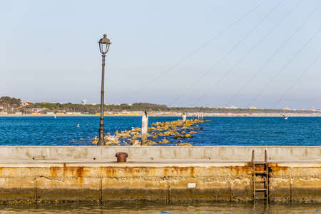 seagulls on poles among the sea rocks in Italyの写真素材