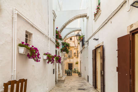 locorotondo in Apulia, Italy, hanging flowers of whitewashed houses on narrow streetsの写真素材