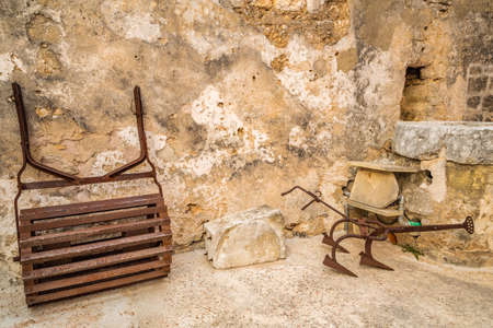 Italy, old devices and rusty spare parts in threshing floor of peasant houseの写真素材