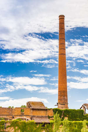 chimney of old disused factory covered by Virginia creeperの写真素材