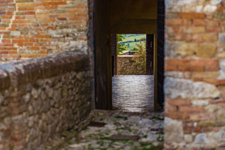 Italian green countryside view through doors in ancient buildingの写真素材