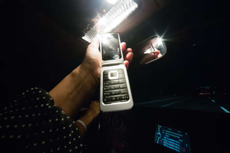 woman making a call while husband driving on highwayの写真素材