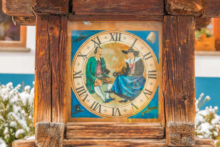 old wooden watch in street of a snowy Alpine village in Italy