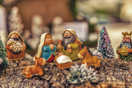 vivid colors of a Christmas Nativity scene, the Blessed Virgin Mary and Saint Joseph watch over the Holy Child Jesus in a manger as the ox and the donkey are warmingの写真素材