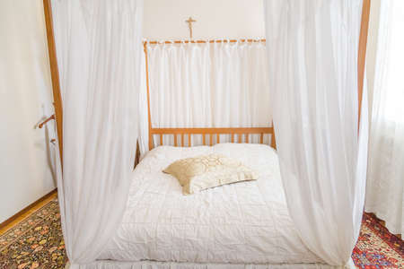 bedroom with four-poster bed and carpetsの写真素材