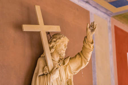 wooden sculpture of Jesus Christ holding the Cross
