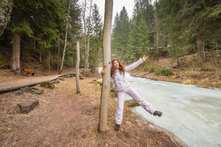 happy woman having fun and dancing near frozen riverの写真素材