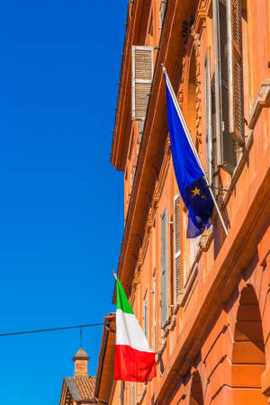 Italian and Europe flags on the Architecture of the colorful buildings of Modena in Italyの写真素材