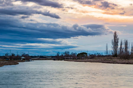 sunset on a lagoon with sea water with fishing hutsの写真素材