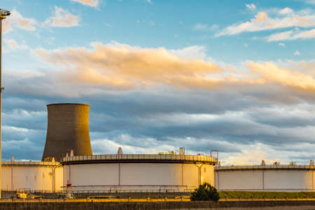 smokestacks and storage silos of the port terminal industries at sunsetの写真素材