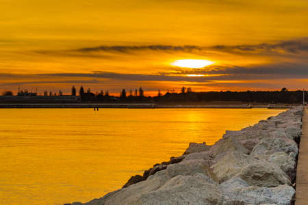 sunset on the pier leading to the coastの写真素材