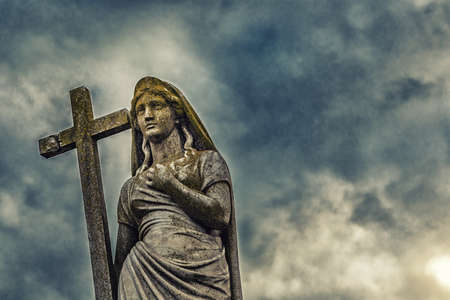 statue of woman holding The Holy Cross