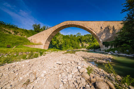 Quiet river flowing under Renaissance single-span bridge  near Bolognaの写真素材