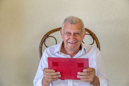 Excited and happy elderly man using tablet computerの写真素材
