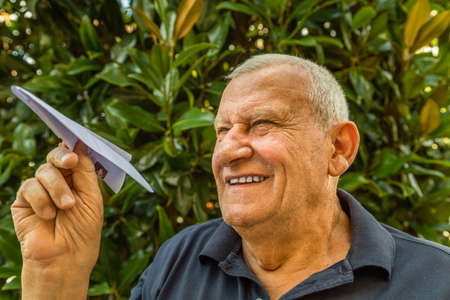Elder playing with paper airplaneの写真素材