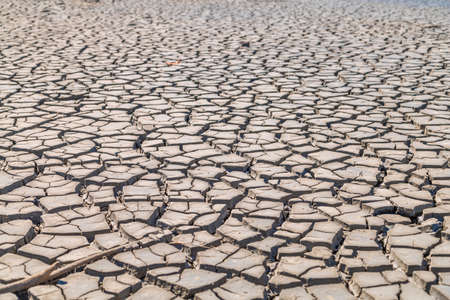 cracked clay soil texture backgroundの写真素材