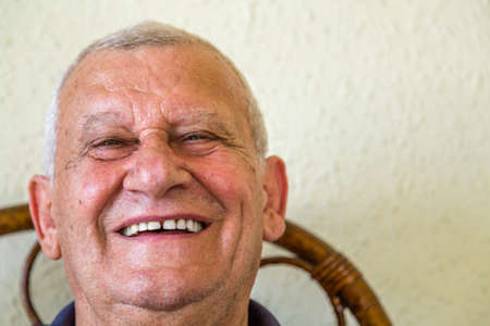 elderly smiling while sitting on wicker chairの写真素材