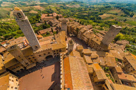 Dizzy top view of the medieval village of San Gimignano near Siena under the sun of Tuscanyの写真素材
