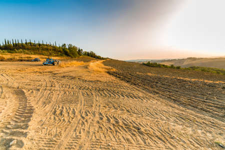 tracks and tractor in orange countryside in Italyの写真素材