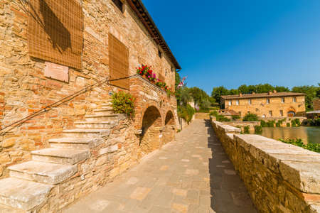 unusual public square in medieval village near Siena under the sun of Tuscany in Italyの写真素材