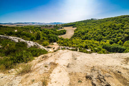 green weeds and arid rocks the  region of badlands under the sun of Tuscany in Italyの写真素材