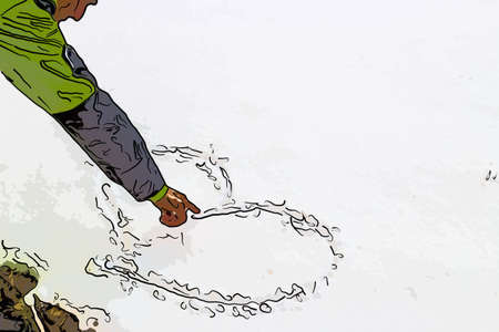 hand of a man who is drawing a heart in the snowの写真素材