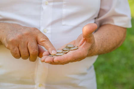 old man counting euros in a green gardenの写真素材