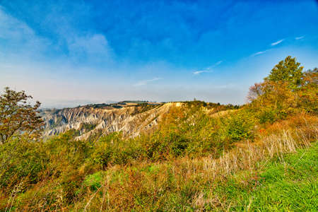 landscape of badlands and green hill with trees in autumn sunny day