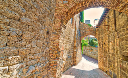 stone arch in street of San Gimignano, Italyの写真素材