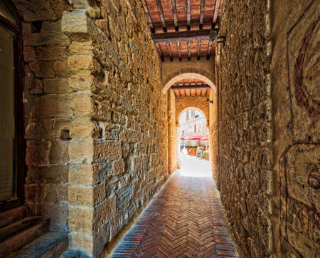 stone arch in street of Volterra, Italyの写真素材