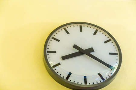 round wall clock on yellow backgroundの写真素材
