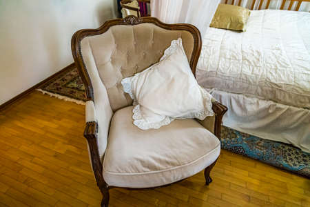armchair with soft pillows in cozy bedroomの写真素材