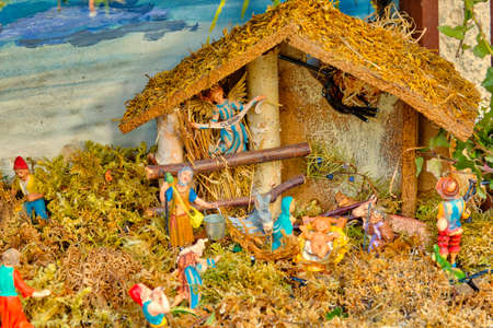 Nativity scene with The Holy Child, The Blessed Virgin Mary, Saint Joseph, ox and donkey in hut with angel, sheep and shepherdsの写真素材