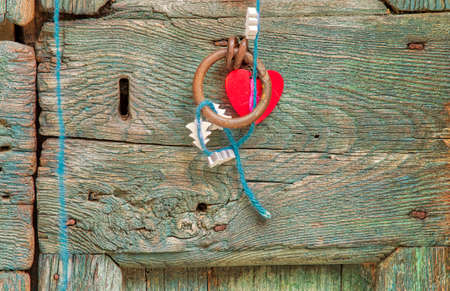 hanging heart and Christmas tree on handle of old wooden doorの写真素材