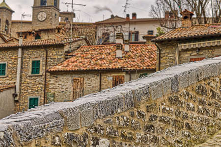 view of roofs of cozy Italian medieval village from ancient bridgeの写真素材