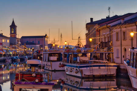 blue hour at sunset on the Christmas decorations of port channel of Cesenatico, best tourist destination of the Romagna Riviera in Italyの写真素材