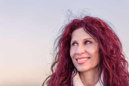 menopausal woman with red cherry hair  smilingの写真素材