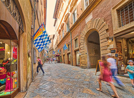 VOLTERRA, ITALY - AUGUST 31, 2017:  Tourists going shopping in the historic center of Volterraのeditorial素材