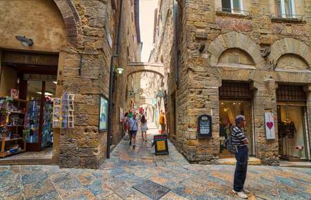 VOLTERRA, ITALY - AUGUST 31, 2017:  Tourists going shopping in the historic center of Volterraのeditorial素材