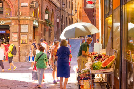 BOLOGNA, ITALY - AUGUST 27, 2016:  tourists and locals go shopping in medieval market. The trade vocation of this area known as Quadrilatero, meaning The Quadrilateral Area, was born in Middle Agesのeditorial素材